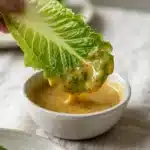 Tasting honey mustard salad dressing on a lettuce leaf