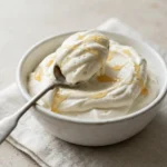 Honey whipped cream served in a small bowl with honey drizzle